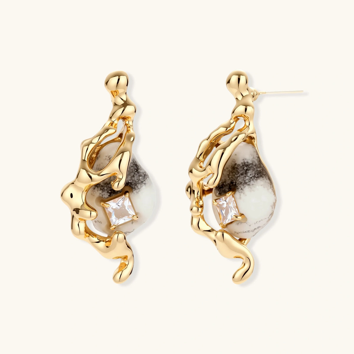 Close-up of metallic dragon-wrapped earrings with marbled resin stones on white background