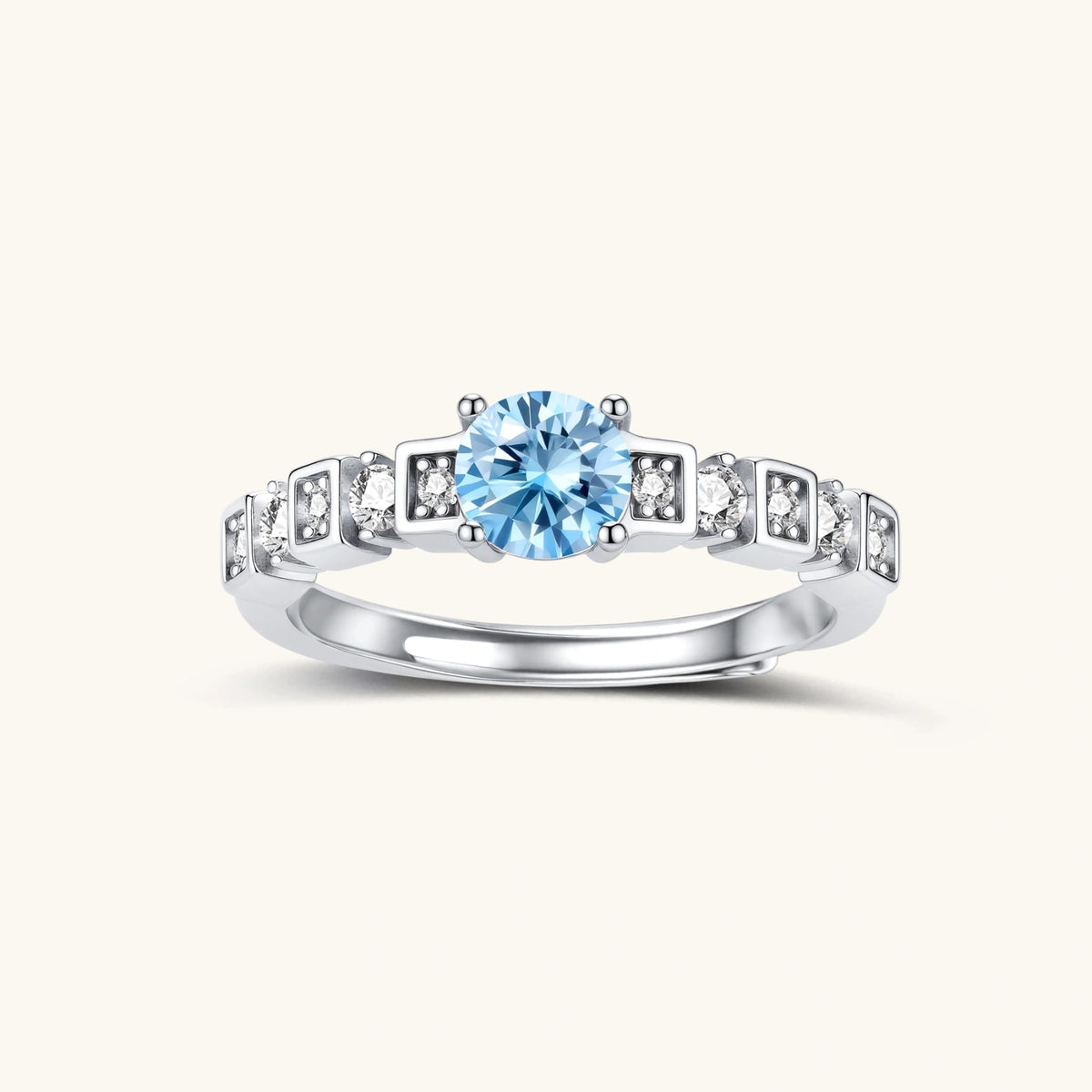 Geometric sterling silver ring with light blue moissanite center stone and square diamond accents on white background