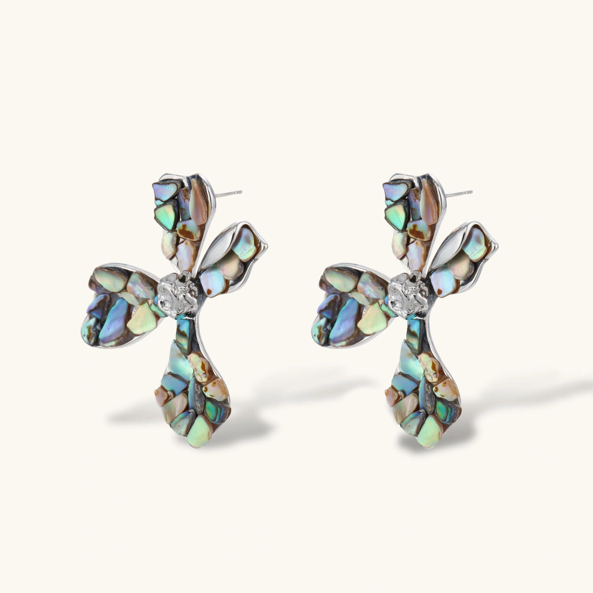 Cross-shaped stud earrings with iridescent abalone shell mosaic in blues and greens, silver-plated setting with crystal center