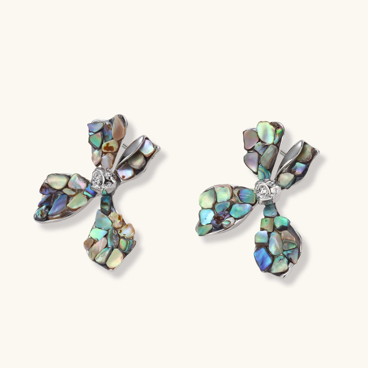Cross-shaped stud earrings with iridescent abalone shell mosaic in blues and greens, silver-plated setting with crystal center