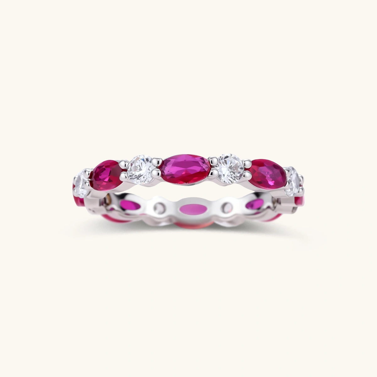 Platinum-plated eternity ring with alternating oval ruby and round clear stones in continuous band setting