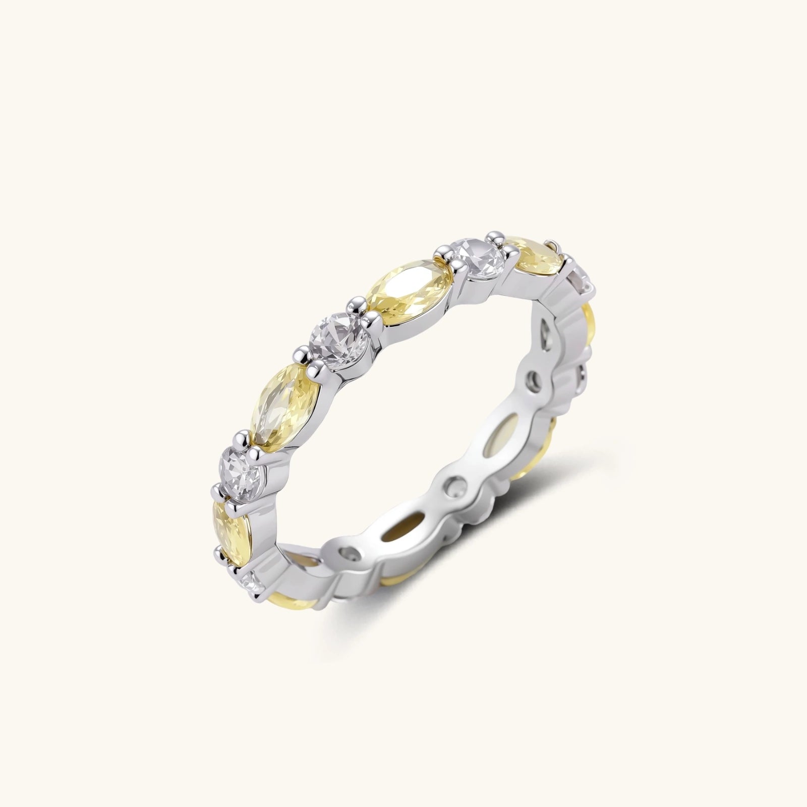 Platinum-plated copper ring with alternating clear and pale yellow oval stones in an eternity band design on white background.